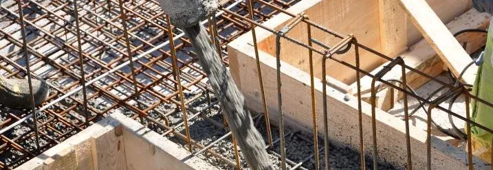 Flüssiger Beton wird in ein Fundament gegossen.